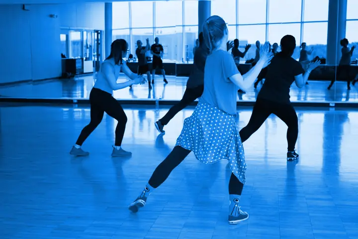 Grupo bailando frente al espejo en una clase de danza